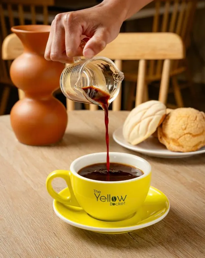 Café con arte latte en taza amarilla